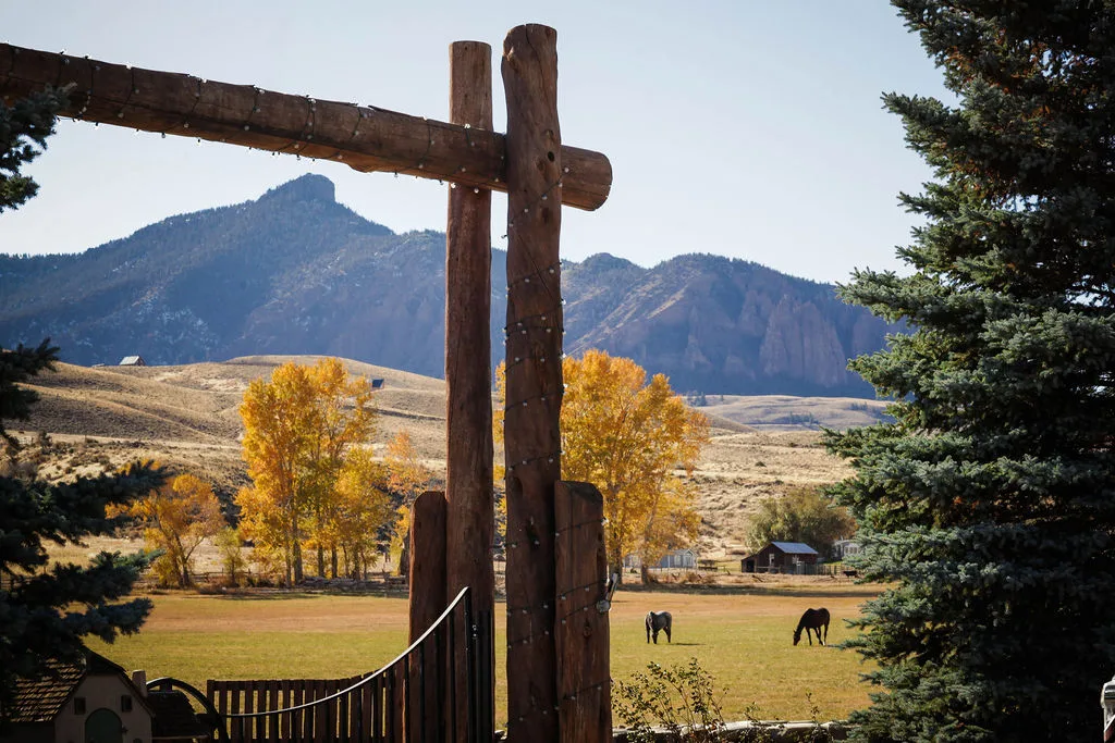 Custom timber entrance gate with horses and fall foliage