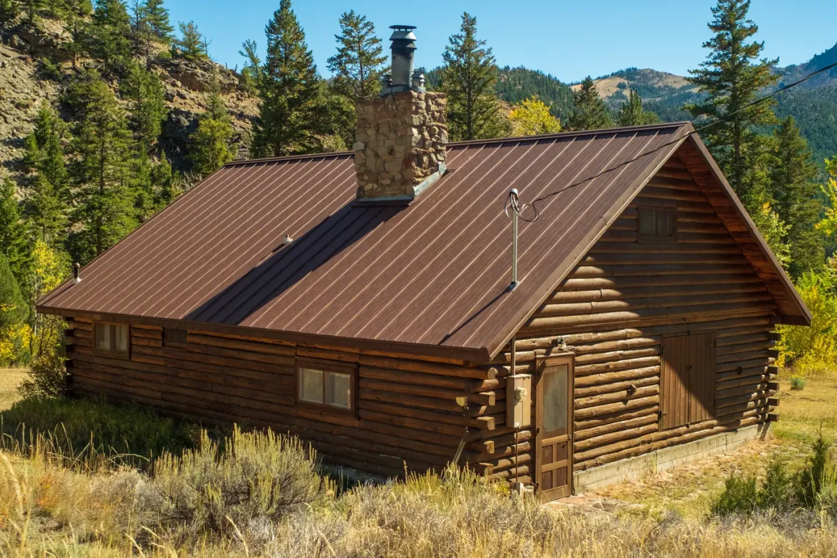 Restored cabin with stone chimney in mountain setting