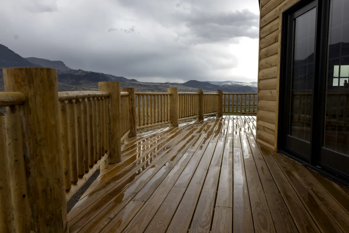 Log cabin deck with mountain views by Pilot Peak Construction
